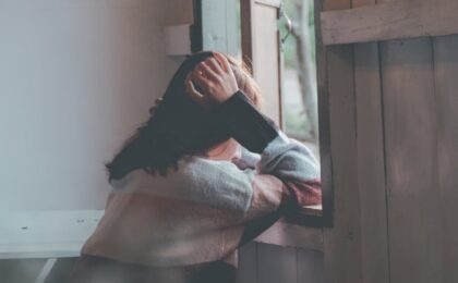 photo of a person leaning on wooden window