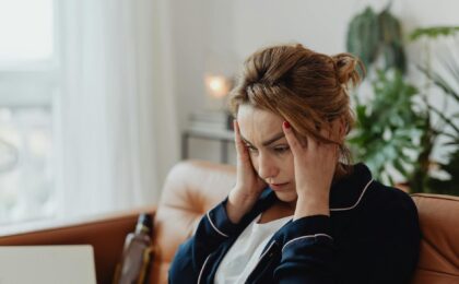 woman wearing a pajama holding her head