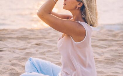 a woman meditating at the beach